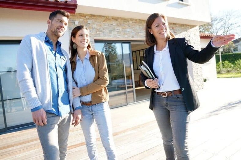 A real estate agent giving a couple a tour of their new home.